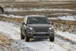 Picture of a driving 2015 Land Rover Discovery Sport HSE Luxury in Kaikoura Stone Metallic from a frontal perspective