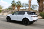 Picture of a driving 2015 Land Rover Discovery Sport HSE Luxury in Fuji White from a rear left three-quarter perspective