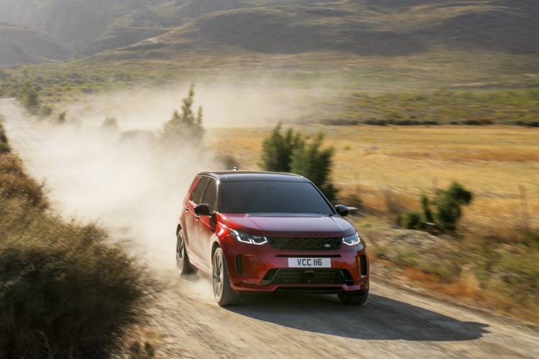 Picture of a driving 2020 Land Rover Discovery Sport P290 HSE R-Dynamic in Firenze Red Metallic from a front right perspective