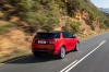 Picture of a driving 2020 Land Rover Discovery Sport P290 HSE R-Dynamic in Firenze Red Metallic from a rear right perspective
