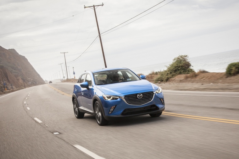 Picture of a driving 2016 Mazda CX-3 in Dynamic Blue Mica from a front right three-quarter perspective