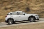 Picture of a driving 2016 Mazda CX-3 AWD in Crystal White Pearl Mica from a side perspective