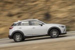 Picture of a driving 2018 Mazda CX-3 AWD in Snowflake White Pearl Mica from a side perspective