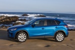 Picture of a driving 2014 Mazda CX-5 in Sky Blue Mica from a left side perspective