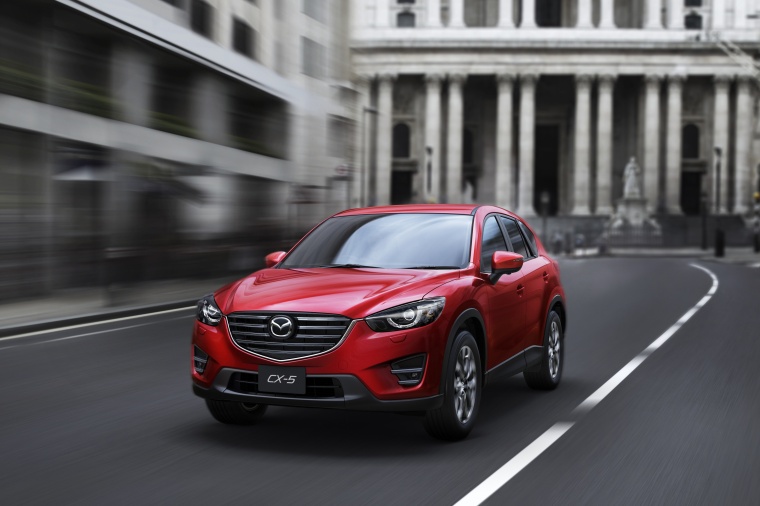 Picture of a driving 2016 Mazda CX-5 AWD in Soul Red Metallic from a front left perspective