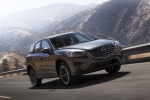 Picture of a driving 2016 Mazda CX-5 in Meteor Gray Mica from a front right perspective