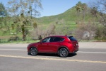 Picture of a driving 2017 Mazda CX-5 Grand Touring AWD in Soul Red Crystal Metallic from a rear left three-quarter perspective