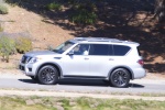 Picture of a driving 2017 Nissan Armada Platinum in Brilliant Silver from a side perspective