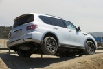 Picture of a driving 2017 Nissan Armada Platinum in Brilliant Silver from a rear right three-quarter perspective
