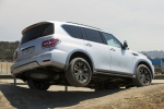 Picture of a driving 2019 Nissan Armada Platinum in Brilliant Silver from a rear right three-quarter perspective