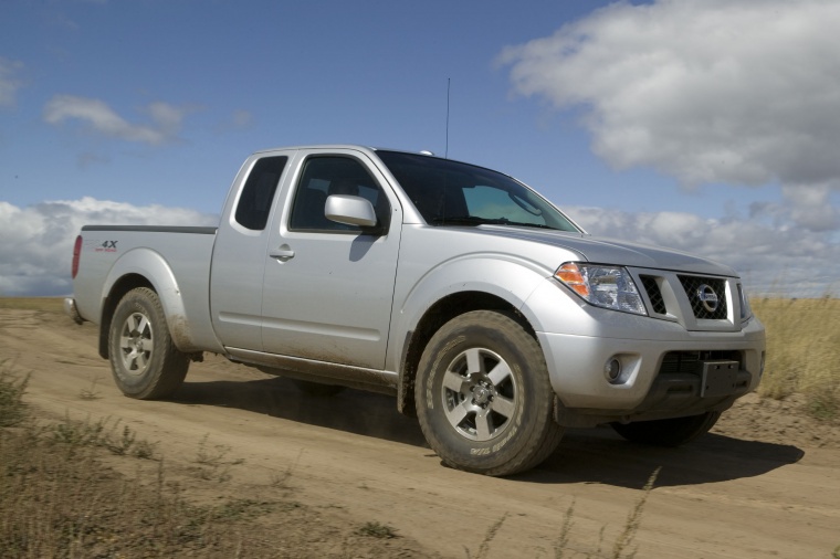 Picture of a driving 2014 Nissan Frontier King Cab PRO-4X 4WD in Brilliant Silver from a front right three-quarter perspective