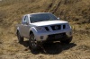 Picture of a driving 2014 Nissan Frontier King Cab PRO-4X 4WD in Brilliant Silver from a front right perspective