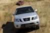 Picture of a driving 2014 Nissan Frontier King Cab PRO-4X 4WD in Brilliant Silver from a frontal perspective
