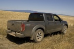 Picture of a driving 2014 Nissan Frontier Crew Cab PRO-4X 4WD in Night Armor from a rear right three-quarter perspective