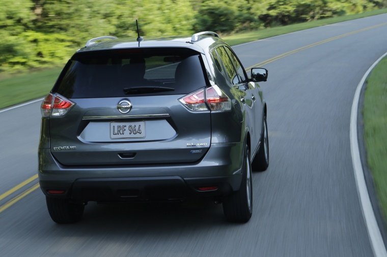 Picture of a driving 2014 Nissan Rogue SL AWD in Graphite Blue from a rear right perspective