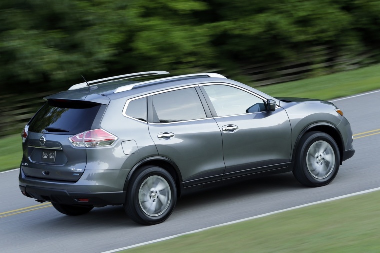 Picture of a driving 2014 Nissan Rogue SL AWD in Graphite Blue from a rear right three-quarter perspective
