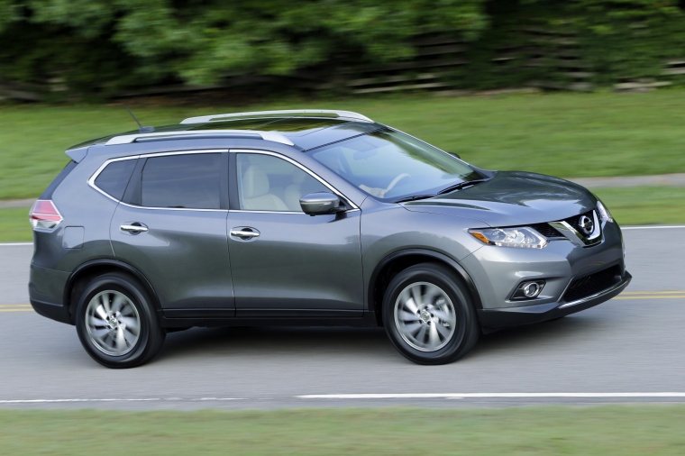 Picture of a driving 2014 Nissan Rogue SL AWD in Graphite Blue from a front right three-quarter perspective