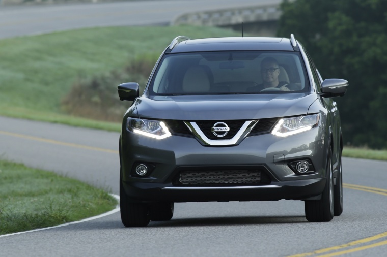 Picture of a driving 2014 Nissan Rogue SL AWD in Graphite Blue from a frontal perspective