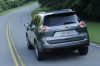 Picture of a driving 2014 Nissan Rogue SL AWD in Graphite Blue from a rear left perspective