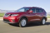 Picture of a driving 2014 Nissan Rogue SL AWD in Cayenne Red from a front left three-quarter perspective