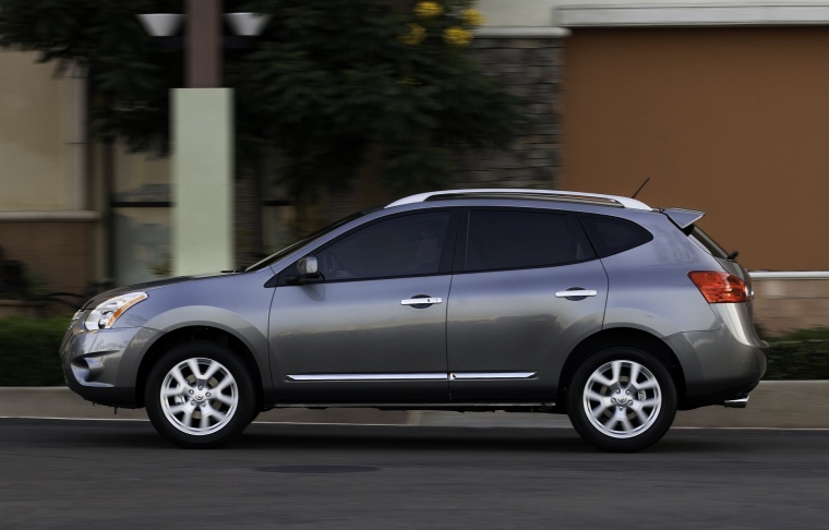 Picture of a driving 2014 Nissan Rogue Select in Platinum Graphite from a side perspective