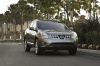 Picture of a driving 2014 Nissan Rogue Select in Platinum Graphite from a frontal perspective