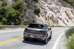 Picture of a driving 2015 Porsche Macan Turbo in Agate Gray Metallic from a rear right perspective