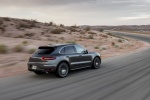 Picture of a driving 2015 Porsche Macan Turbo in Agate Gray Metallic from a rear right three-quarter perspective