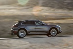 Picture of a driving 2015 Porsche Macan Turbo in Agate Gray Metallic from a right side perspective