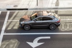 Picture of a driving 2015 Porsche Macan Turbo in Agate Gray Metallic from a side top perspective
