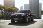 Picture of a driving 2015 Porsche Macan Turbo in Agate Gray Metallic from a front left perspective