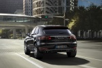 Picture of a driving 2015 Porsche Macan Turbo in Agate Gray Metallic from a rear left perspective