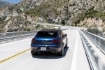 Picture of a driving 2015 Porsche Macan S in Dark Blue Metallic from a rear perspective