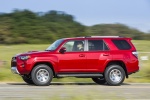 Picture of a driving 2018 Toyota 4Runner TRD Off Road in Barcelona Red Metallic from a side perspective