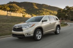 Picture of a driving 2014 Toyota Highlander Limited in Creme Brulee Mica from a front left three-quarter perspective