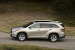 Picture of a driving 2014 Toyota Highlander Limited in Creme Brulee Mica from a side perspective