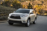 Picture of a driving 2015 Toyota Highlander Limited in Creme Brulee Mica from a front left perspective