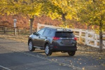 Picture of a driving 2014 Toyota RAV4 Limited in Magnetic Gray Pearl from a rear left three-quarter perspective