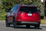 Picture of a driving 2016 Toyota RAV4 SE AWD in Barcelona Red from a rear left perspective