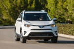 Picture of a driving 2016 Toyota RAV4 Hybrid XLE AWD in Super White from a front right perspective