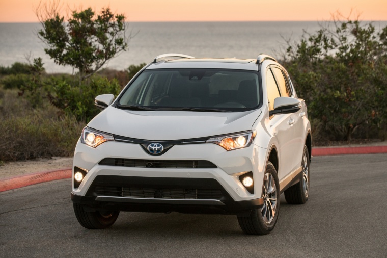Picture of a driving 2017 Toyota RAV4 Hybrid XLE AWD in Super White from a front left perspective