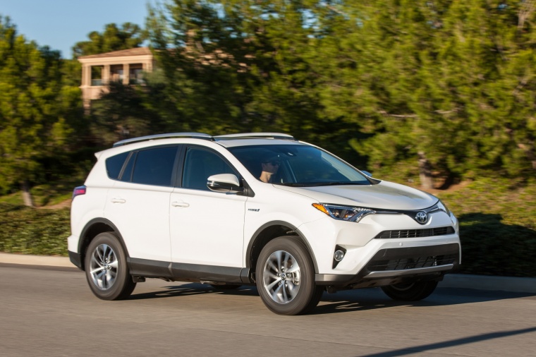 Picture of a driving 2017 Toyota RAV4 Hybrid XLE AWD in Super White from a front right three-quarter perspective