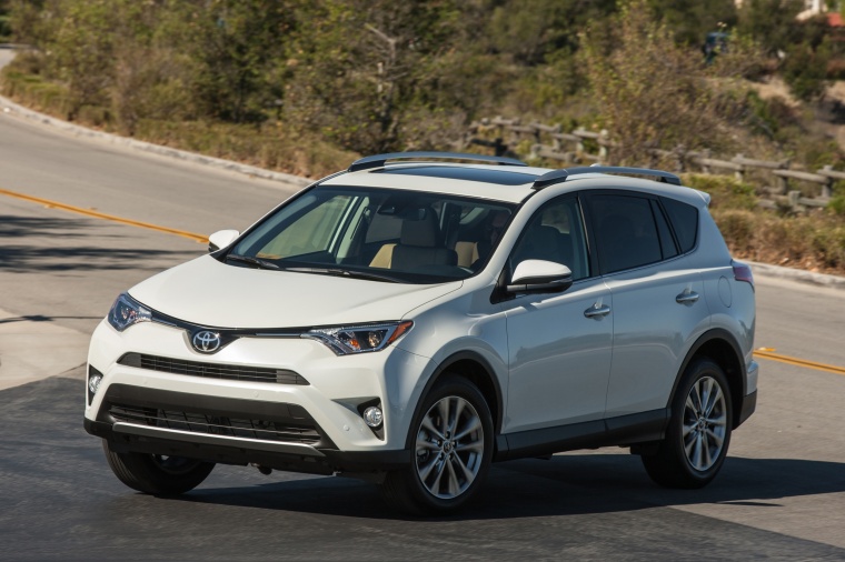 Picture of a driving 2017 Toyota RAV4 Hybrid XLE AWD in Super White from a front left three-quarter perspective