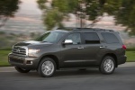Picture of a driving 2016 Toyota Sequoia in Pyrite Mica from a front left perspective