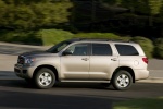 Picture of a driving 2016 Toyota Sequoia in Sandy Beach Metallic from a left side perspective