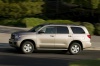 Picture of a driving 2017 Toyota Sequoia in Sandy Beach Metallic from a left side perspective