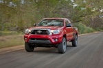 Picture of a driving 2014 Toyota Tacoma Access Cab V6 4WD in Barcelona Red Metallic from a front left three-quarter perspective