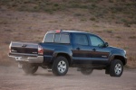 Picture of a driving 2014 Toyota Tacoma Double Cab SR5 V6 4WD in Blue Ribbon Metallic from a rear right three-quarter perspective