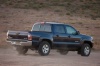 Picture of a driving 2015 Toyota Tacoma Double Cab SR5 V6 4WD in Blue Ribbon Metallic from a rear right three-quarter perspective
